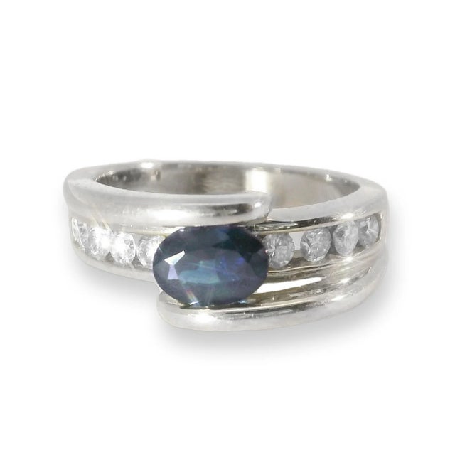 This stunning 14K white gold ring features a deep blue natural oval sapphire beautifully accented by 8 brilliant round...