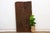 This antique Nupe door from Nigeria is carved across four narrow vertical planks, each carrying its own distinct emblem...