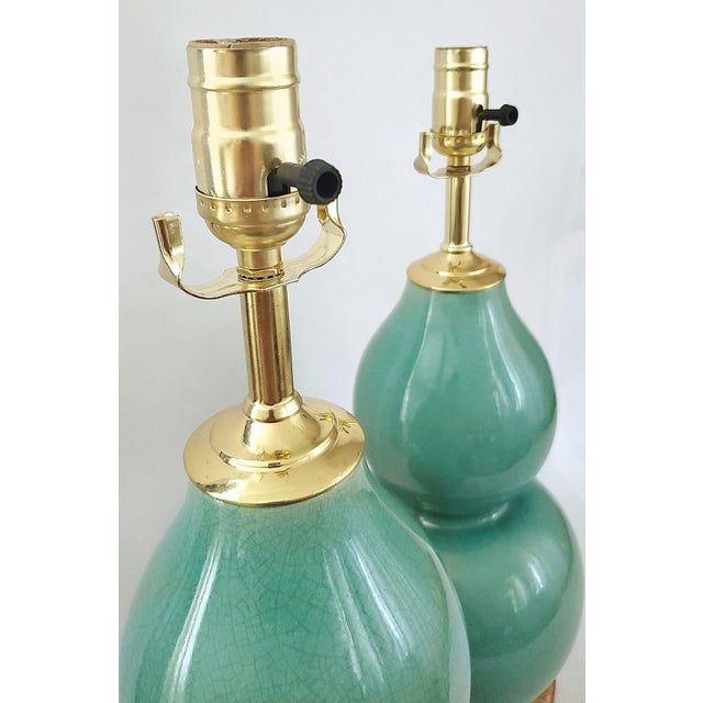 Offering a pair of beautiful coastal blue/turquoise crackled porcelain double gourd shaped table lamps, circa Late 20th...