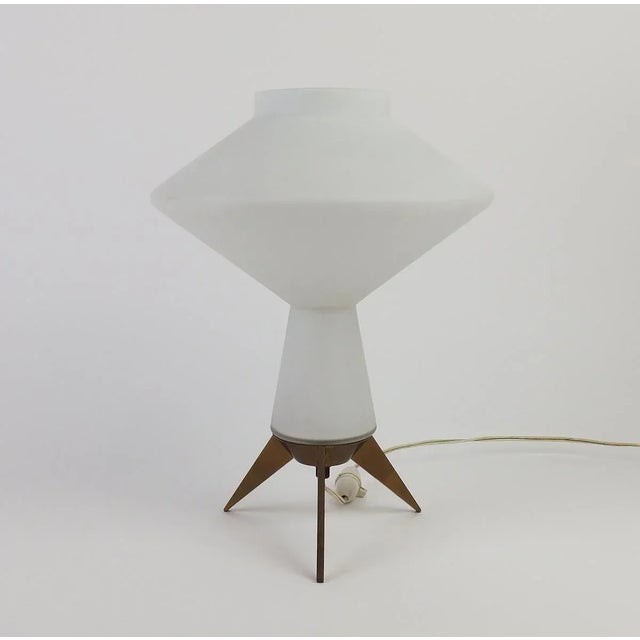 Lamp with a tripod brass base supporting an opalescent white glass diffuser, in the Stilnovo style, circa 1950. European...