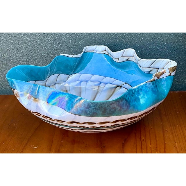 This striking art glass bowl is a masterful example of the Murano glassblowing tradition, featuring a fluid, wavy rim that...