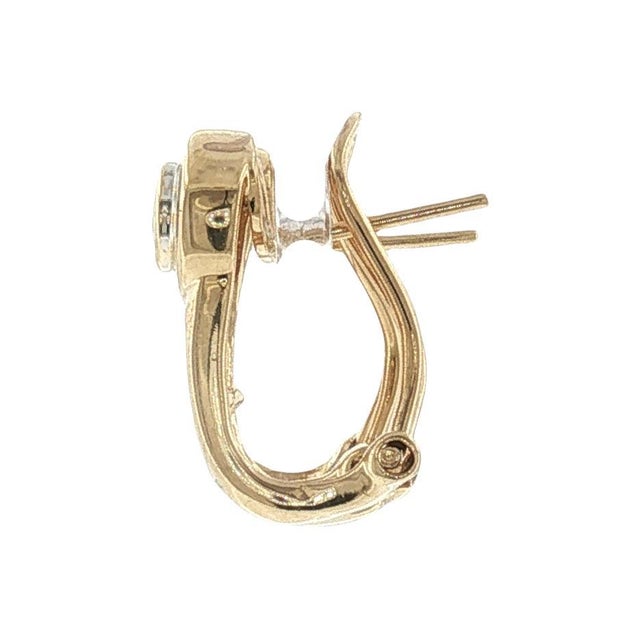 A pair of late 20th-century 14k gold hoop earrings featuring brilliant-cut diamonds. The primary stones are 18 white...