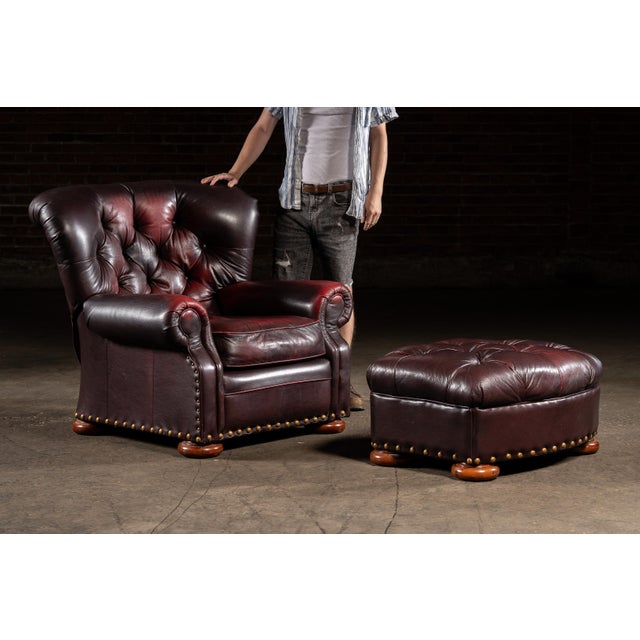 Deeply tufted and richly upholstered in oxblood leather, this Churchill-style recliner pairs classic English club design...