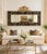 A very substantial size late 20th-century mirror featuring a hand-painted black panel with scrolling floral motifs, framed...