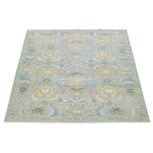 Experience the elegance of this exquisite hand-knotted Sultanabad wool rug, showcasing a serene light blue background...