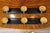 1950s ebonized wood coat rack featuring three brass medallion knobs. Each medallion is decorated with relief portraits of...