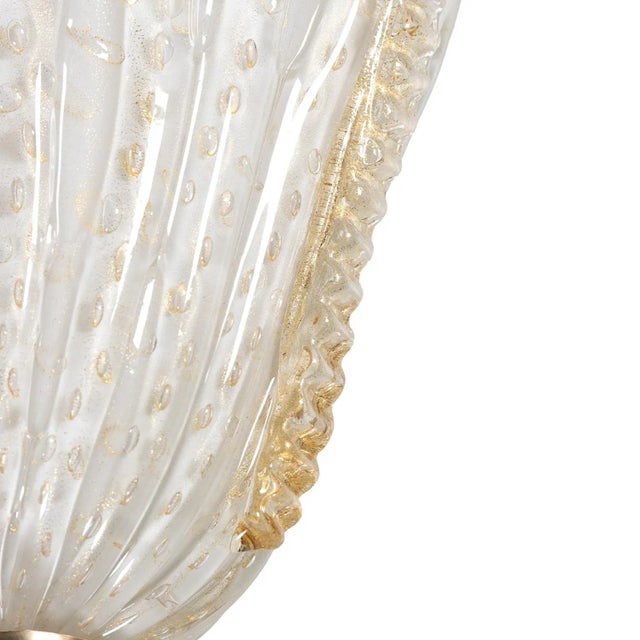 Refined design for this Murano glass wall light. The lamp is composed of a semi-cup (containing the light bulb) in white...