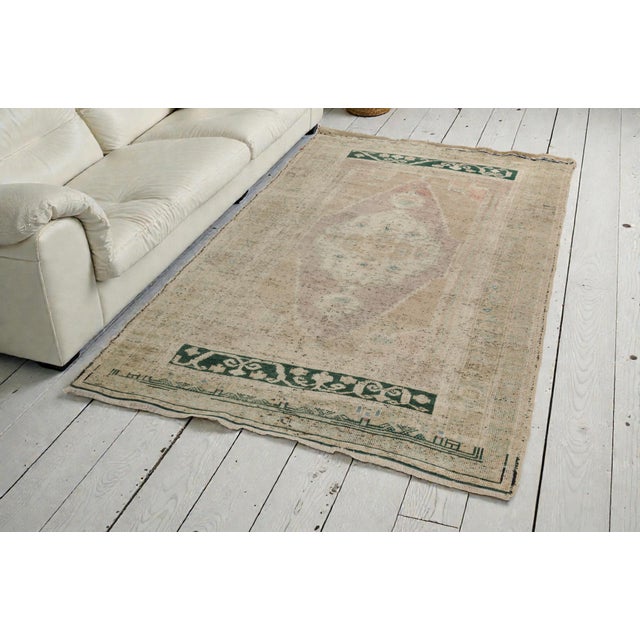 This is a vintage Turkish Oushak rug from the Mid 20th Century. The piece was hand-knotted.