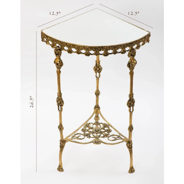 A Spanish highly decorative corner console table in brass with three legs with figural male faces and mirror top, circa...