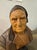A hand-carved linden wood bust depicting an elderly man with detailed facial features and a distinctive cap.. Please...