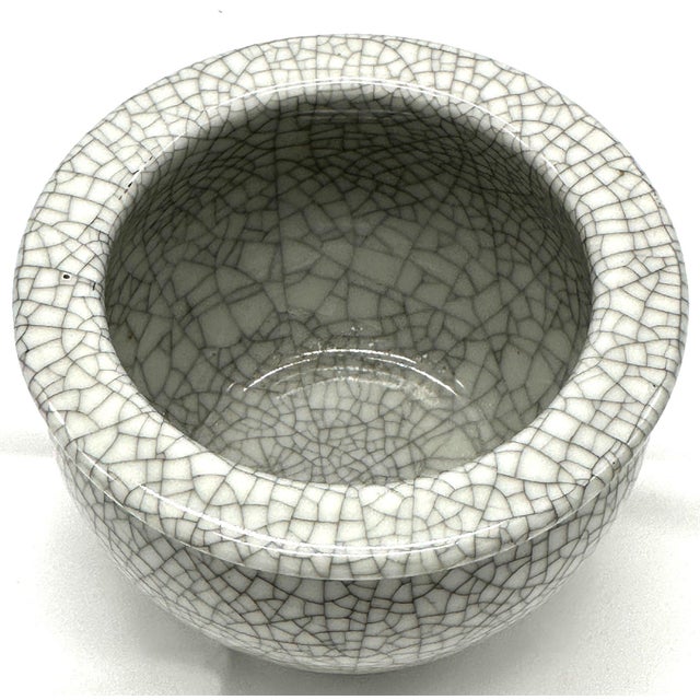 This vintage crackle-glaze ceramic cachepot features a softly rounded silhouette finished in a luminous ivory glaze with...