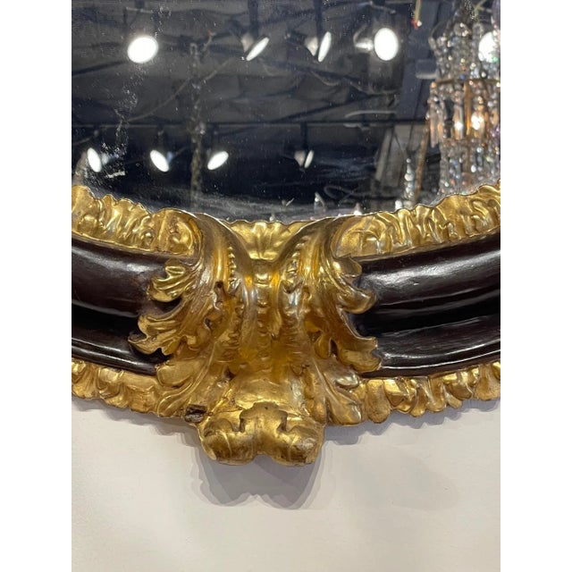 Handsome 18th century Italian carved wood and ebonized mirror with gilded details. Round mirrors are more scarce and this...