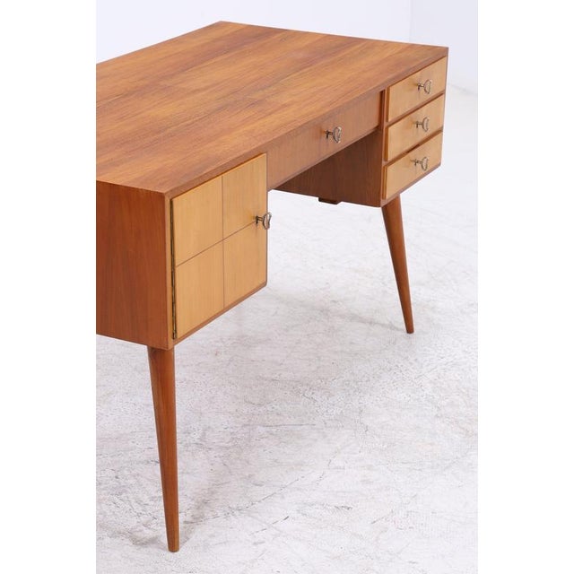 Vintage desk with clean lines and a well-organized front. Three drawers are located on the right, and there is a central...