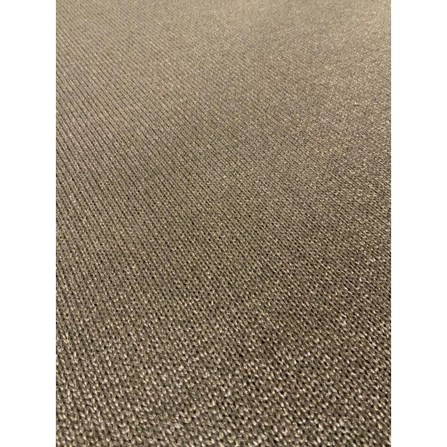 This neutral fabric is a taupe solid with a metallic silver thread. It is woven with a knit design. It has a course hand...