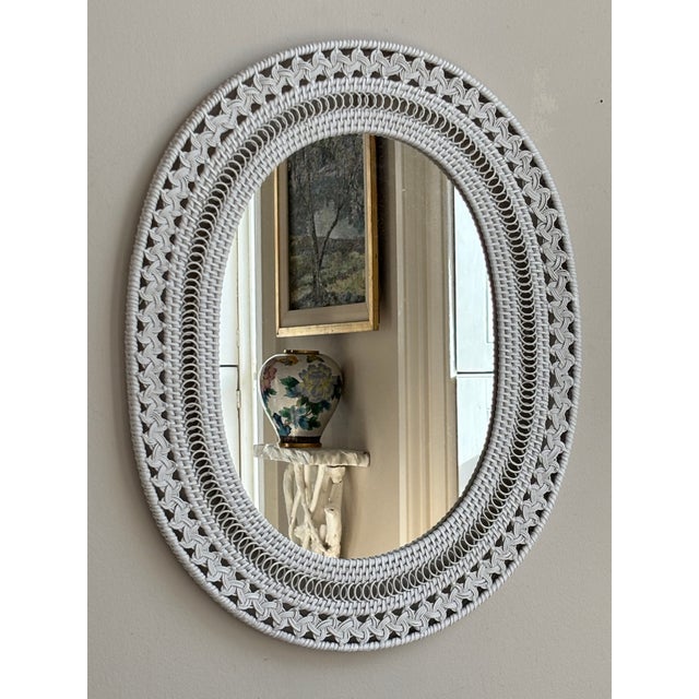 A lovely boho white wicker wall mirror from the mid- to late-20th century. This gorgeous mirror features a very intricate...