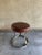 Laced leather and steel stool. Leather seat stenciled in French. Base in worn and weathered steel. Comfortable and...