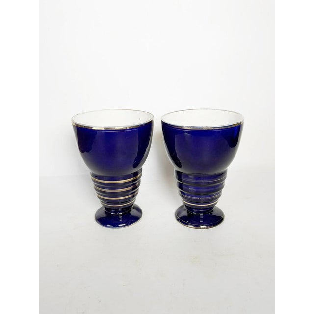 Pair of blue ceramic vases, France, circa 1960. An elegant pair of vases with a slender silhouette, resting on a ringed...
