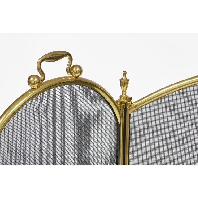 Brass and wire mesh three-part folding and adjustable fireplace screen with brass finials and handles.
