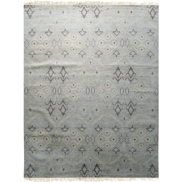 A hand-knotted wool rug, made in India and measuring 8' x 10'. Floral drawing carried across the field inside a...