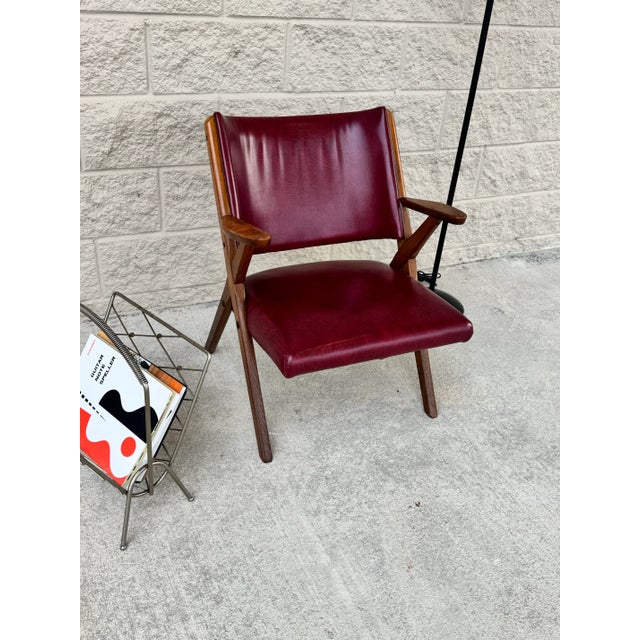 Italian mid-century modern armchair, C. 1950s. Designed with curved back, X-form hardwood frame, shaped arms, enclosing...