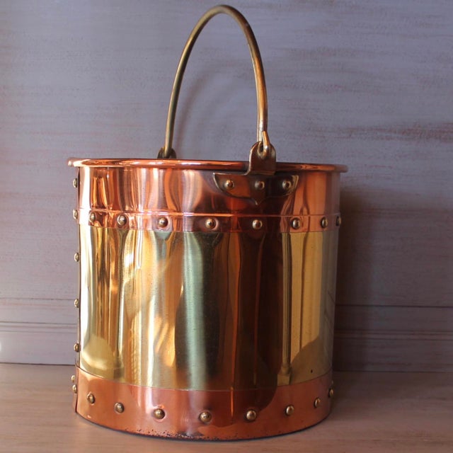 A substantial brass fireplace bucket banded top and bottom with copper, and attractively studded along the seams with...