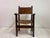 A Spanish armchair dating to the early 20th century, constructed in solid wood with a rich, warm patina and fitted with...