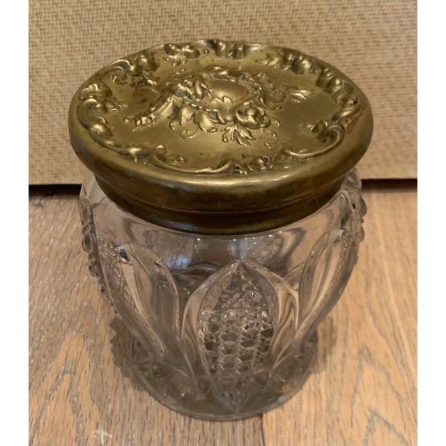 Antique British biscuit jar with ornate silverplate decorative lid and traditional etched glass detail on jar.