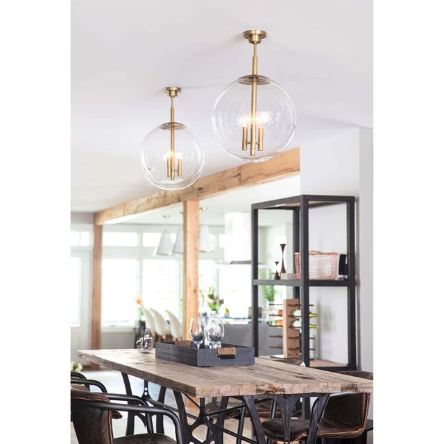 The clear glass shade of the Cafe Pendant acts as a barely-there surround on the metal rod, column and arms. The metal cap...