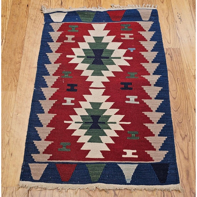 A striking example of traditional Anatolian flatweave artistry, this vintage mid-20th century Turkish kilim features a...