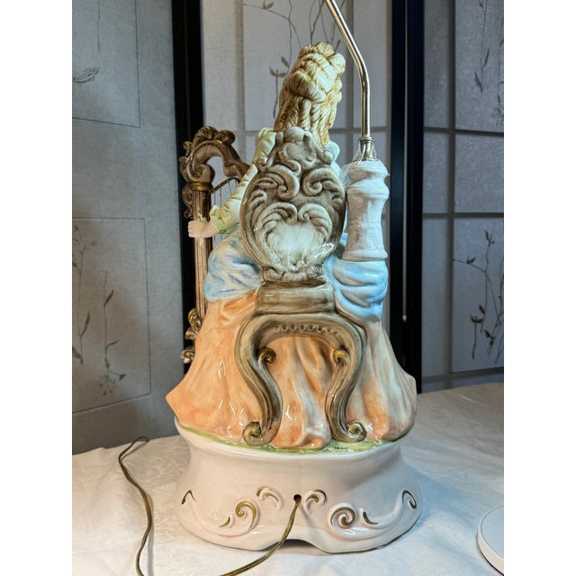 This exquisite Capodimonte figural table lamp features a lovely, seated harp player wearing a Baroque era costume. The...