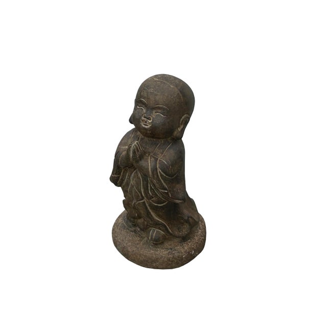 The Zen Oriental Dark Gray Stone Anjali Mudra Standing Cute Lohon Monk Statue exudes tranquility and grace, capturing the...