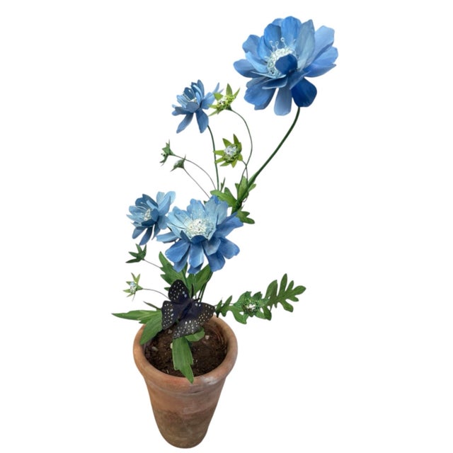 This charming vintage-style metal floral sculpture features vibrant cornflower-blue blooms crafted with multi-layered,...