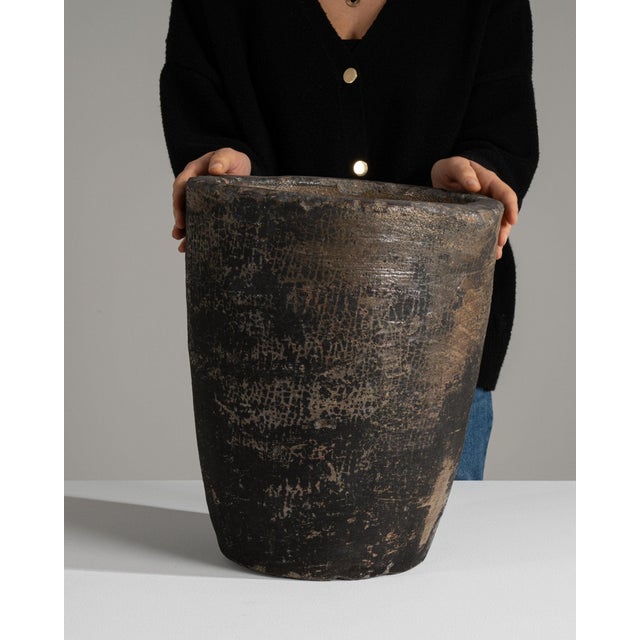 Here is a planter/urn, its dark bronze/black textured patina, tapered round form the first thing to catch the eye. The...