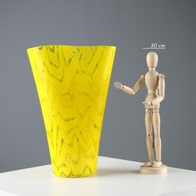 Yellow and colorless blown glass vase with soft, sinuous lines. Manufacturer's mark engraved under the base. Small...