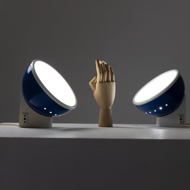 Pair of Pollice table lamps. Adjustable hemispherical blue painted metal diffuser with a white plastic front diffuser....