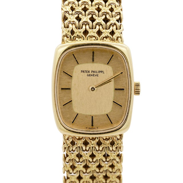 Vintage Patek Philippe ladies wristwatch features a two-tone champagne dial with gold bar hour indexes and gold baton...