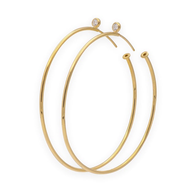 A pair of Tiffany & Co. Elsa Peretti hoop earrings crafted in 18K yellow gold, accented with bezel-set round brilliant...