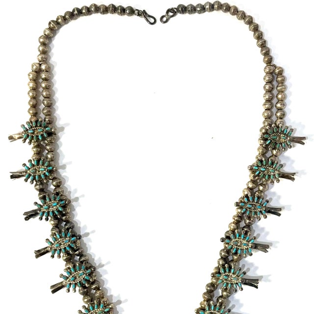 Since the late 19th century Zuni artisans have been crafting "Squash Blossom" necklaces. Their design merges Spanish and...