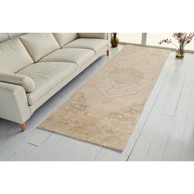 This is a vintage Turkish Oushak rug from the Mid 20th Century. The piece was hand-knotted.