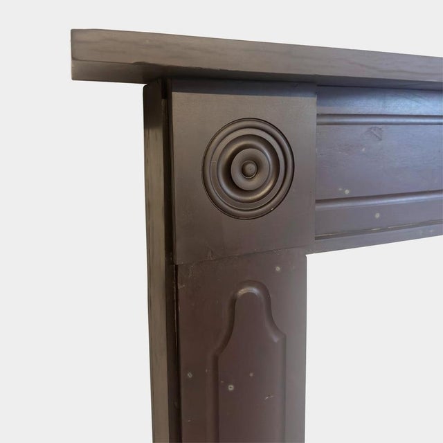 A pair of bangor or '' plum"" slate fireplaces from the regency period. Both with shaped mouldings to front panels, with...