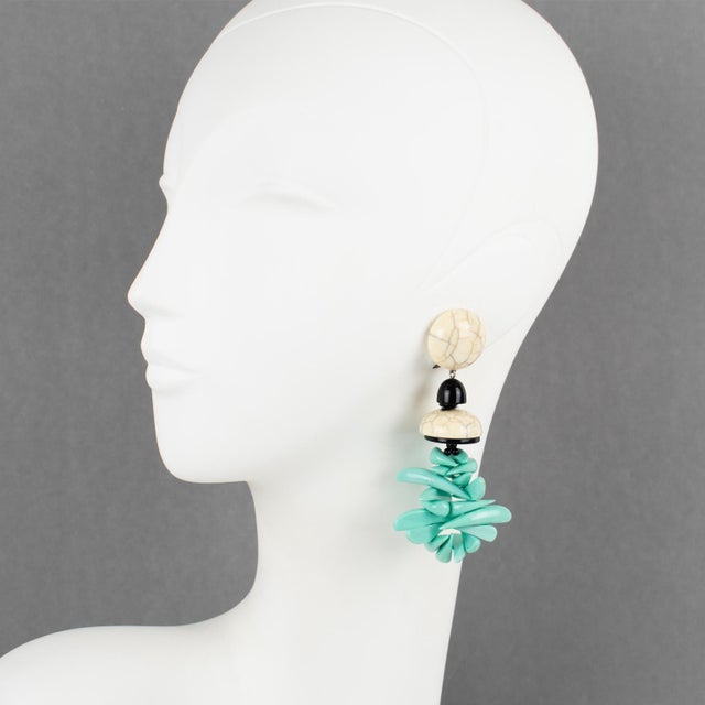 These stunning Angela Caputi, made-in-Italy resin clip-on earrings feature a massive dangling shape with faux marble...