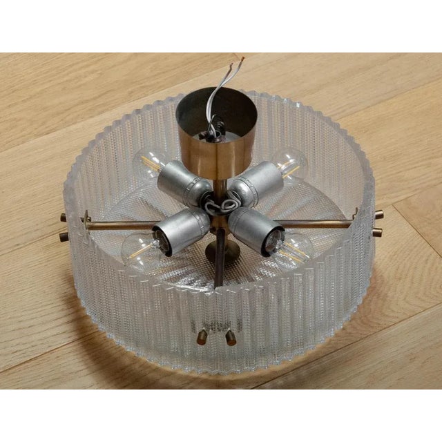 Ceiling lamp designed by Carl Fagerlund, manufactured by Orrefors, Sweden, 1960s. This elegant fixture features a brass...