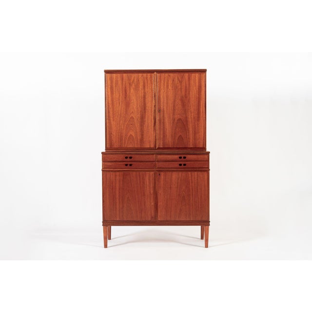 This vintage mid century Danish modern tall teak wood storage cabinet is circa 1960. This unique cabinet is elegantly...