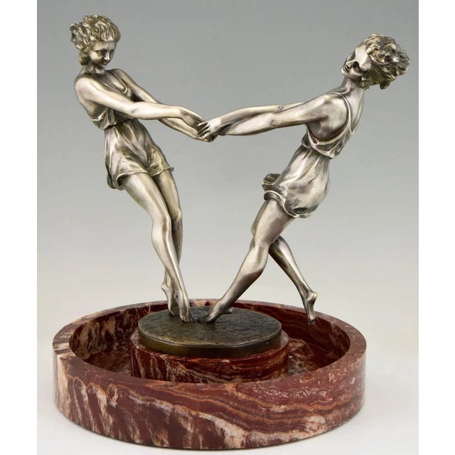 Whirling, spectacular circular marble centerpiece with a bronze sculpture of two dancing girls holding hands by the French...