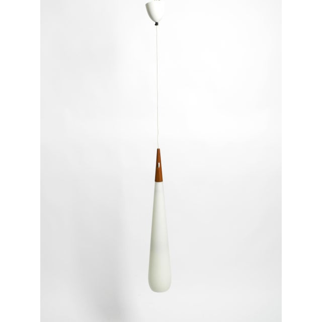 Beautiful, very rare long pendant lamp made of teak and opal glass, designed in 1957 by uno & östen kristiansson....