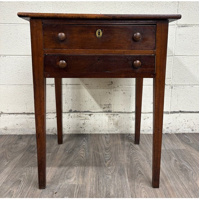 This is a charming antique primitive two-drawer work table or sewing stand, likely American and dating to the 19th...