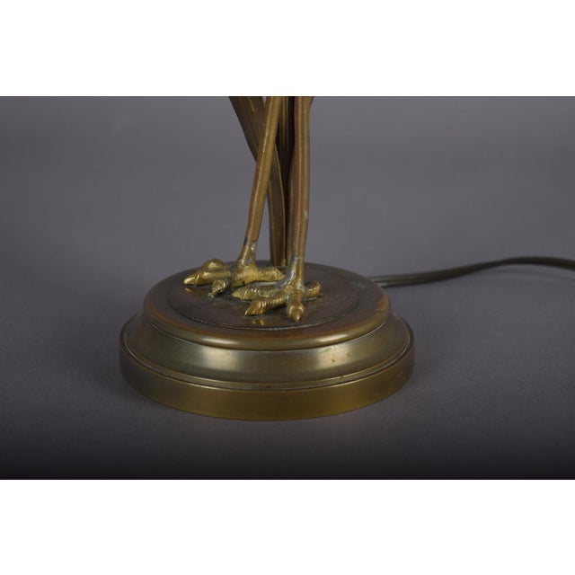 A striking and highly decorative crane table lamp, crafted in gilt-toned metal with beautifully sculpted plumage and an...