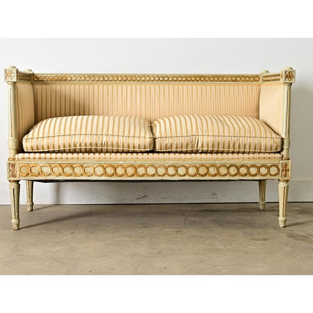 Swedish 19th Century Louis XVI/Gustavian settee featuring a painted, parcel gilt frame and gorgeous upholstery of...