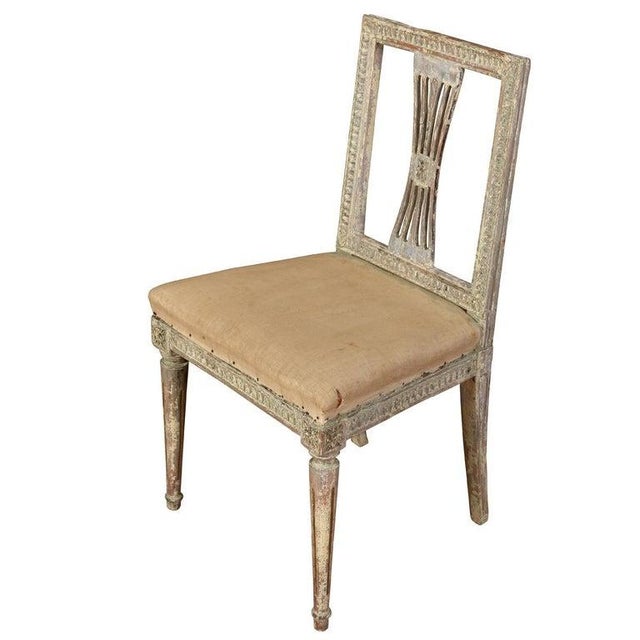 A finely carved set of four Gustavian period side chairs from Sweden, featuring square backs with pierced splats, fluted...