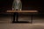 Industrial worktable constructed from a long two-board oak plank top mounted to a repurposed cast iron treadle-style base....